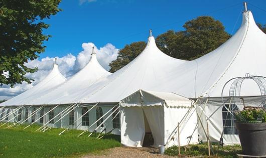 tall green portable restrooms assembled at a music festival, contributing to an organized and sanitary environment for guests in Greenport